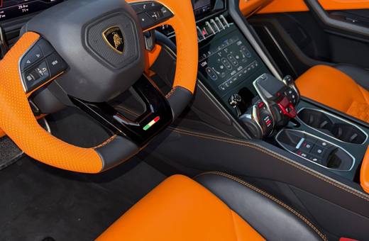 Lamborghini Urus S orange and black steering wheel and dash