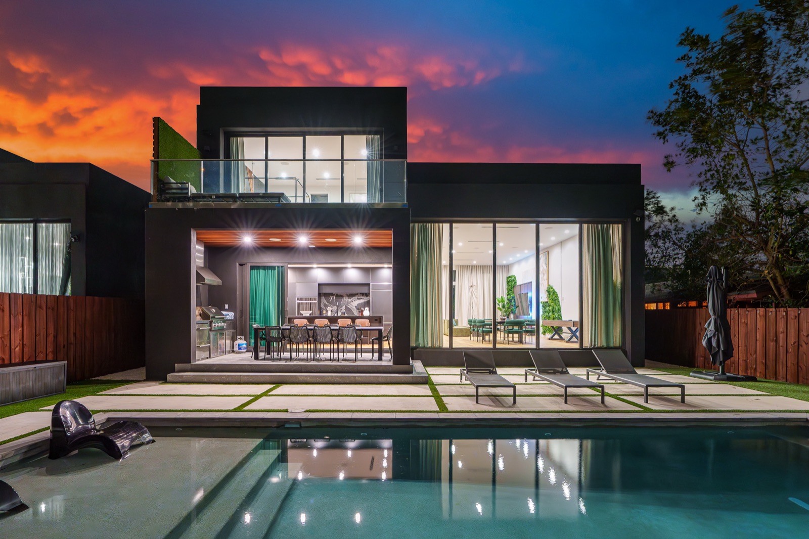 Villa Eden at dusk — black modern house, lit interior, pool reflection